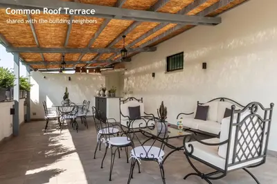 a patio with chairs and tables and a couch at Castro Pretorio 24 - FromHometoRome in Rome