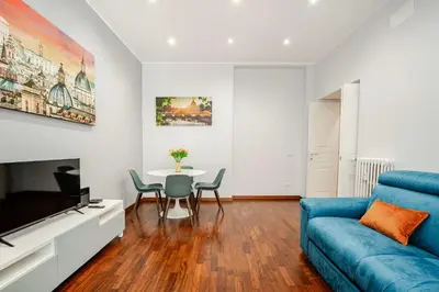 a living room with a blue couch and a table at Roma San Pietro - Vatican Vibes apartment in Rome