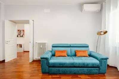 a blue couch with two orange pillows in a living room at Roma San Pietro - Vatican Vibes apartment in Rome