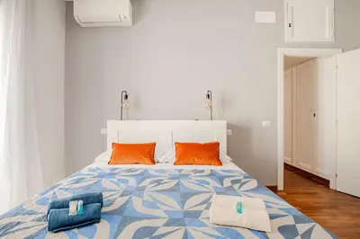 a bedroom with a large bed with orange pillows at Roma San Pietro - Vatican Vibes apartment in Rome