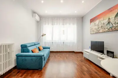 a living room with a blue couch and a television at Roma San Pietro - Vatican Vibes apartment in Rome