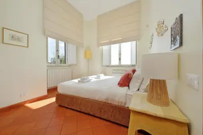 a bedroom with a bed and a lamp on a table at Piazza di Spagna Cozy House & Amazing View in Rome