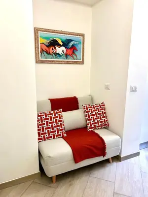 a couch in a room with a painting on the wall at Vacanze Romane at Furio Camillo in Rome