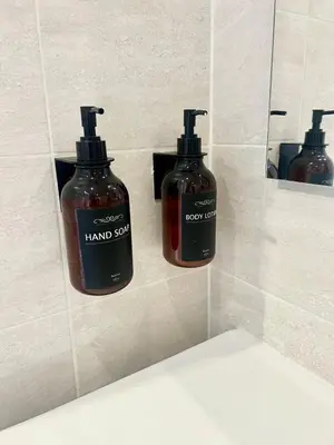 two bottles of hand soap on the wall of a bathroom at Vacanze Romane at Furio Camillo in Rome