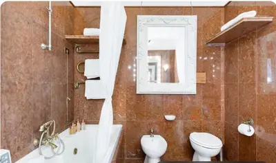 a bathroom with a tub and a toilet and a sink at Spacious Penthouse with Stunning Views of Historic Landmarks in Rome