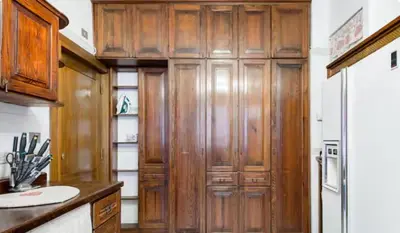 a kitchen with wooden cabinets and a refrigerator at Spacious Penthouse with Stunning Views of Historic Landmarks in Rome