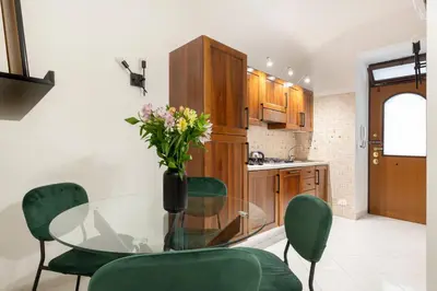 a kitchen with a glass table and green chairs at White Flat Sanniti in Rome