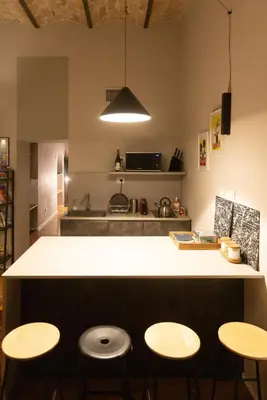a kitchen with a counter and two stools at Trastevere Spot in Rome