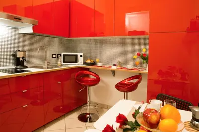 a kitchen with red cabinets and a table with fruits at Termini in Bed in Rome