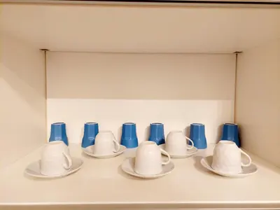 a row of blue and white cups and saucers at Lovely Flat Roma Università in Rome