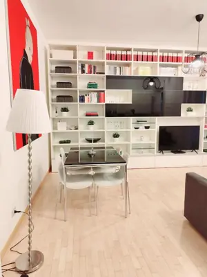 a living room with a glass table and white shelves at Lovely Flat Roma Università in Rome