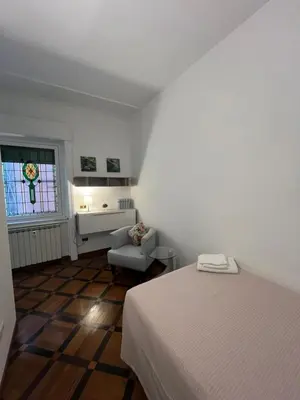 a bedroom with a bed and a window and a chair at HOUSE BOCCEA Rome in Rome