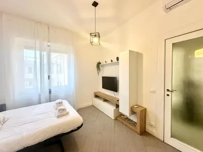a white room with a bed and a television at Sergio I Apartment in Rome