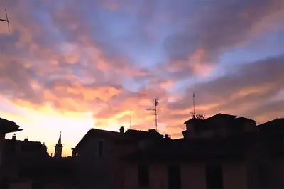 a sunset over a city with a cloudy sky at Nido tra le cupole, terrazza panoramica, Wi-Fi , AC in Rome