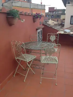 a patio table and chairs on a balcony at Nido tra le cupole, terrazza panoramica, Wi-Fi , AC in Rome