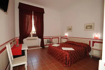 a bedroom with a bed and a table and a window at Startermini in Rome