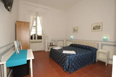a bedroom with a bed and a desk and a window at Startermini in Rome