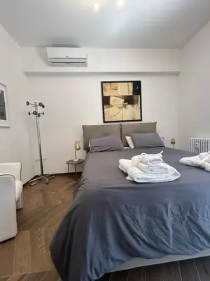 a bedroom with a large bed with a blue blanket at Maison Fortuna in Rome