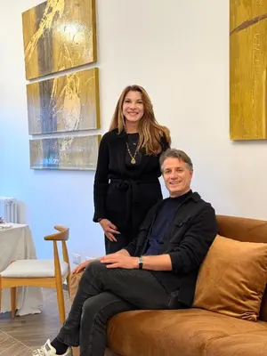 a woman standing behind a man sitting on a couch at Maison Fortuna in Rome