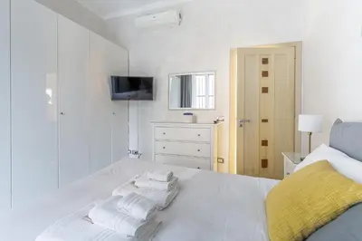 a white bedroom with a bed with towels on it at Iflat Cozy Flat at two steps from Vatican in Rome