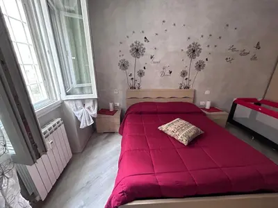 a bedroom with a red bed with flowers on the wall at Breath of Rome 5 min a piedi metro B San paolo poche fermate dal centro di Roma in Rome