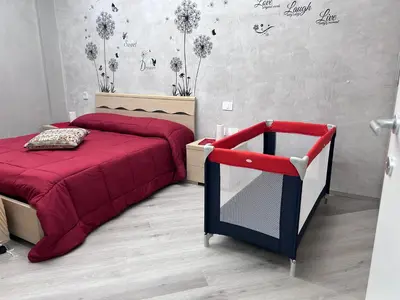a bedroom with a red bed and a red chair at Breath of Rome 5 min a piedi metro B San paolo poche fermate dal centro di Roma in Rome
