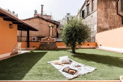 a courtyard with a blanket on the grass at The Best Rent - Peaceful oasis with garden near the Colosseum in Rome
