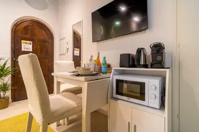a kitchen with a microwave and a table with a chair at Luxury Trevi in Rome
