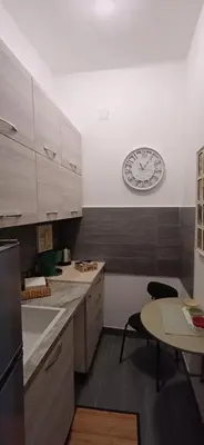 a kitchen with a clock on the wall and a table at Casetta clodio in Rome