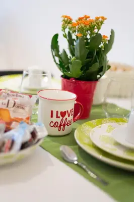 a table with plates and a cup and a plant at Domus Casaletto in Rome