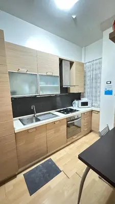 a large kitchen with wooden cabinets and a sink at Casa Gemelli Gemelli in Rome