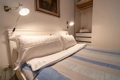 a bed with white sheets and pillows in a room at The Luxury Roma Amor in Rome