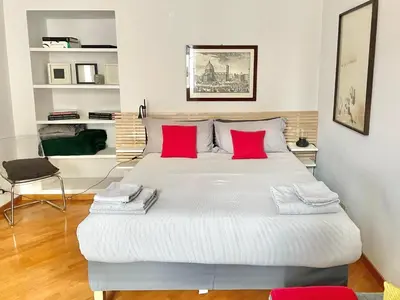 a bedroom with a large white bed with red pillows at Two Bedrooms Spanish Steps Apartment in Rome