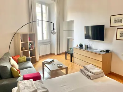 a living room with a couch and a tv at Two Bedrooms Spanish Steps Apartment in Rome
