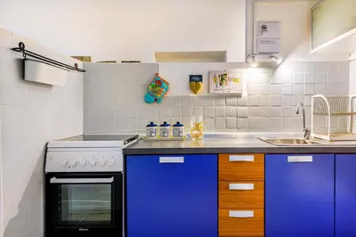 a kitchen with blue cabinets and a sink at Children House Apartment in Rome