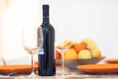 a bottle of wine and two glasses on a table at Children House Apartment in Rome