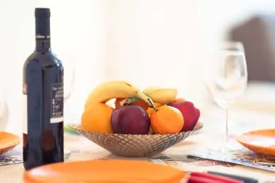 a bowl of fruit on a table with a bottle of wine at Children House Apartment in Rome