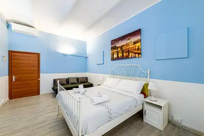 a bedroom with a white bed and a blue wall at Children House Apartment in Rome