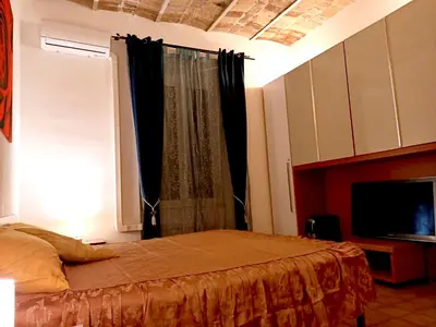 a bedroom with a bed with a window and a tv at 2B Domus Vaticana 