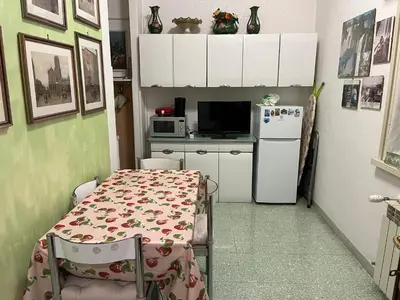 a small kitchen with a table and a refrigerator at Domus Amra in Rome