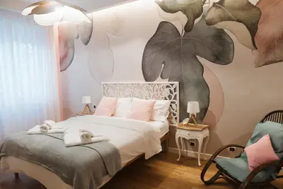 a bedroom with a bed with a flower mural on the wall at A Casa di Emy in Rome