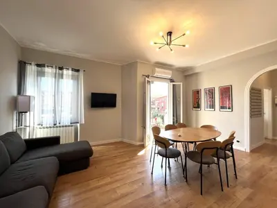 a living room with a table and chairs at L'affaccio sul borgo - Adiacente Metro B in Rome
