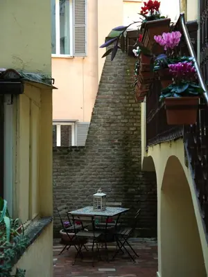 a patio with a table and chairs and a brick wall at Charming Home in Termini in Rome