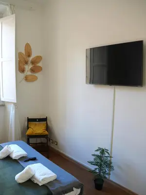 a room with two beds and a tv on the wall at Charming Home in Termini in Rome