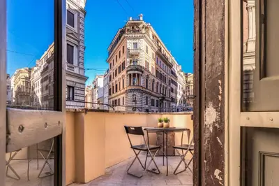 a balcony with a table and chairs and a building at Monti View Apartment in Rome