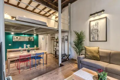 a living room with a couch and a table and a bed at Monti View Apartment in Rome