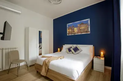 a bedroom with a bed with a blue wall at Vatican Aurelia House - Vicino alla metro e al Vaticano - Luminoso e moderno in Rome
