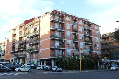 a tall brick building with cars parked in front of it at New Green Hill Apartment - Colli Portuensi in Rome
