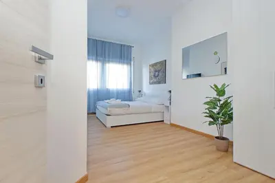 a white living room with a couch and a potted plant at 4BNB - Baldo degli Ubaldi Big Apartment in Rome