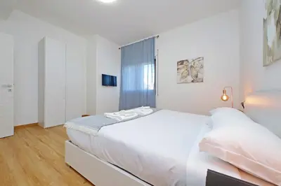 a white bedroom with a large bed and a window at 4BNB - Baldo degli Ubaldi Big Apartment in Rome